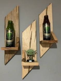 three wooden shelves with two beer bottles and a baby yoda in the bottom one