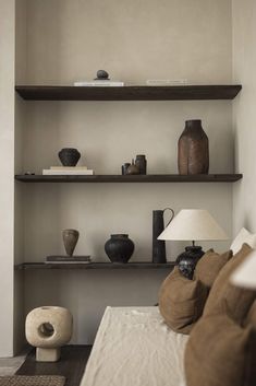 the shelves are filled with vases and other decorative items in this living room area