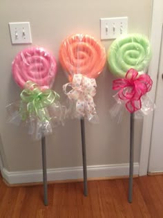 three candy lollipops on sticks with bows