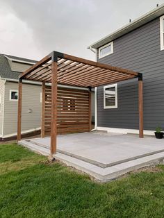 a house that has a wooden pergolan attached to it