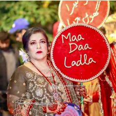 a woman holding a sign that says maa daa ladla