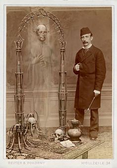 an old photo of a man standing in front of a table with items on it