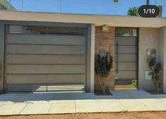 two garage doors are open in front of a house with plants on the sidewalk outside