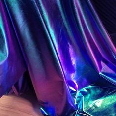 a close up of a purple and blue material on a bed sheet that has been made to look like metallic foil