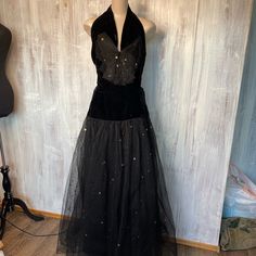 This Stunning Gown Has A Black Tulle And Gold Sparkle Fabric Overlay With A Flair At The Hip And A Velvet Tie Style Neck. Made Of A Velvet Neck Top With A Hidden Zipper On The Side, This Dress Is In Stunning Condition For Its Age! This Also Has A Beautiful Tulle Bow On The Front. This Does Have A Small Tear In The Back And Bottom Hidden In The Tulle And Isn’t Really Noticeable. Ankle Length, This Gown Is Perfect To Twirl Into Your Next Dance Or To Dress Up Like Your Man Is Coming Home From Ww2 ( Or Woman!) Measurements: 36” Bust 28” Waist 36” Hip 66” Long Tulle Black Dress, Sparkle Fabric, Velvet Tie, Tulle Bow, Vintage Dresses 1960s, Tulle Bows, Black Tulle, Stunning Gowns, Tie Styles