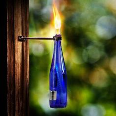 a blue glass bottle with a flame sticking out of it