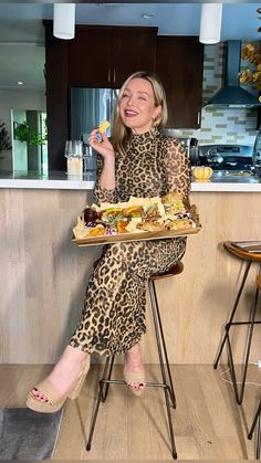 a woman sitting in a chair holding a tray of food