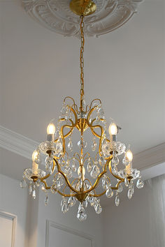 a chandelier hanging from the ceiling in a room with white walls and ceilings