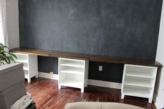 a living room with black walls and white shelves