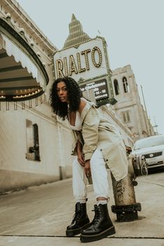 a woman sitting on top of a fire hydrant in front of a theater sign