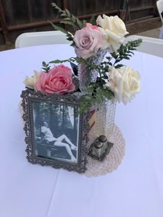 a vase filled with flowers sitting on top of a white table cloth covered tablecloth