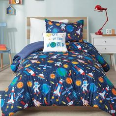 a child's bed with space themed comforter and pillowcases on it