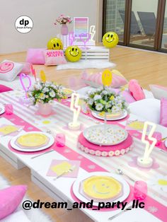 a table set up for a birthday party with pink and yellow plates, flowers and decorations