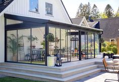 a house with glass walls and patio furniture