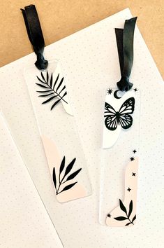 three bookmarks with black and white designs on them, one has a butterfly in the middle