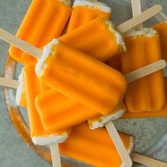 orange pops are on a plate with toothpicks