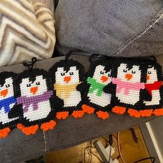 three penguins are sitting on top of a couch