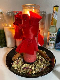 a candle that is sitting on top of a plate with flowers and spices around it