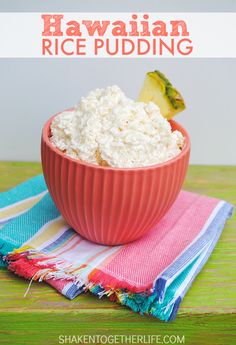 a bowl filled with rice sitting on top of a table next to a napkin and fruit