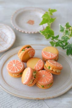 small sandwiches are arranged on a plate next to a plant and paper plates with leaves