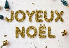 the word joyeuux noel spelled out in gold letters surrounded by small christmas trees