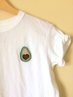 a white t - shirt with an avocado embroidered on it