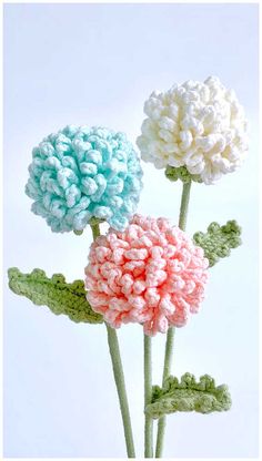 three crocheted flowers are in a vase