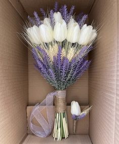 a bouquet of white and purple flowers in a cardboard box