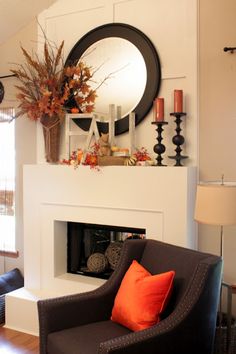 a living room filled with furniture and a fire place under a round mirror on the wall