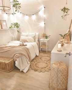 a bedroom decorated in white and pink with lights strung from the ceiling over the bed