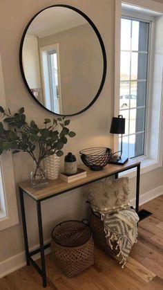 a living room with a mirror, plant and two wicker baskets