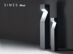 two black and white lamps with the word simes moai on them in front of a dark background