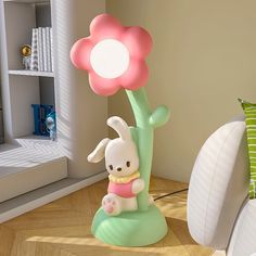 a lamp that is sitting on top of a table next to a stuffed animal and flower