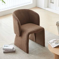 a brown chair sitting on top of a rug next to a table