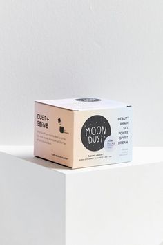 an open box of moon dust sitting on top of a white surface