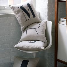 two pillows sitting on top of a chair next to a window