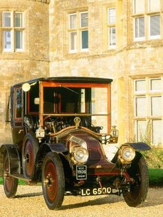 an old fashioned car parked in front of a building