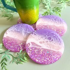 soap covered rocks sitting on top of a table next to a green cup and plant