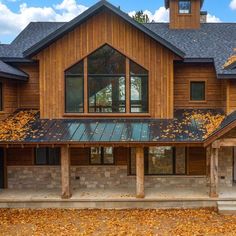 a large house with lots of windows and wood sidings on the front of it