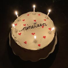 a white cake with red hearts on it and the word nineteen spelled out in black