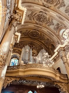 the interior of a church with an ornate ceiling and pipe organ hanging from the ceiling