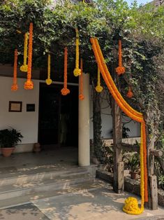 an outdoor area decorated with orange and yellow garlands, hanging from the ceiling above