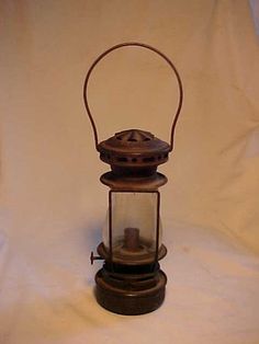 an old fashioned lantern is sitting on a white background with the light shining through it