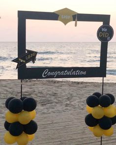 some balloons are hanging from a sign on the beach