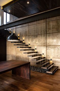 a wooden table sitting in front of a stair case next to a wall with lights on it