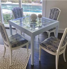 a glass table with blue and white chairs around it