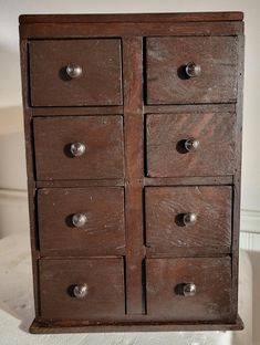 an old wooden cabinet with many drawers on it's sides and knobs at the bottom