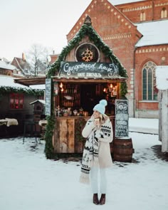 a woman standing in front of a building covered in snow