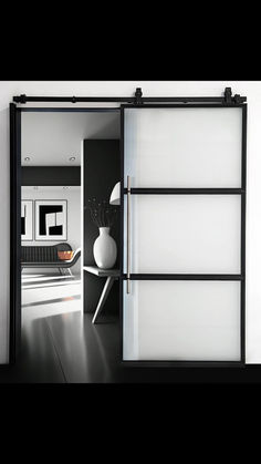 an open sliding door in a room with black and white decor on the wall behind it