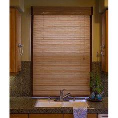 a kitchen with wooden blinds and granite counter tops